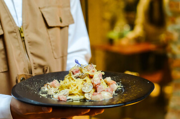 Delicious burgers, potato chips and salads on wooden trays in the restaurant.