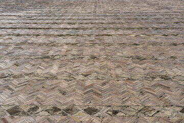The texture of a stone old pavement with a perspective.