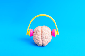 Bright Headphones on Human Brain against Blue Background