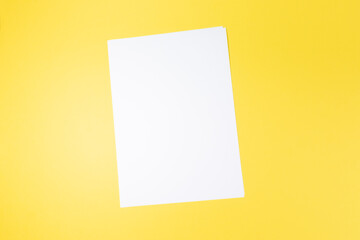 empty white paper sheet and on yellow background. Mockup