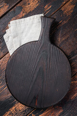 Black wooden Cutting board over towel on kitchen table. Wooden background. Top view. Copy space