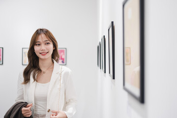 Woman visiting art gallery her looking pictures on wall watching photo frame painting at artwork museum people lifestyle concept.