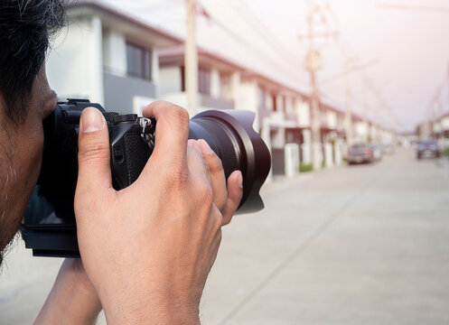 Close up hands of Young Asian photographer taking pictures of housing estates.