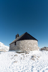the highest located chapel in germany on the zugspitze with bright sunshine and snow covered mountains in the background