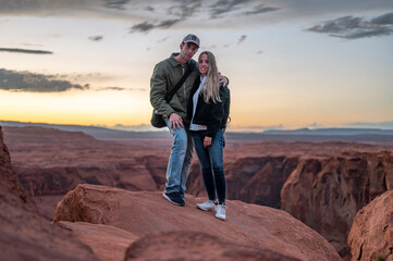 Portrait of a wedding couple, they are standing in the rock formations of the desert at sunset