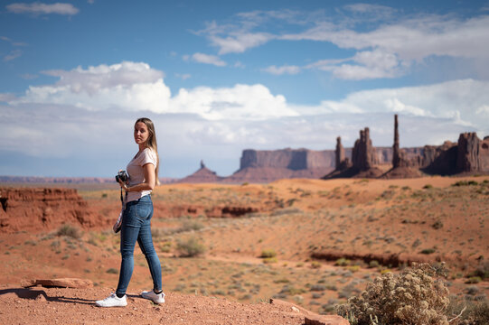 young girl with a vintage photo camera in the desert of Monument Valley