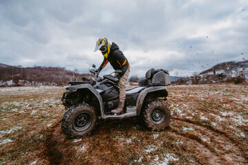 Fototapeta na wymiar A man drives an ATV in the mud. Drift driving an ATV quad in mud and snow