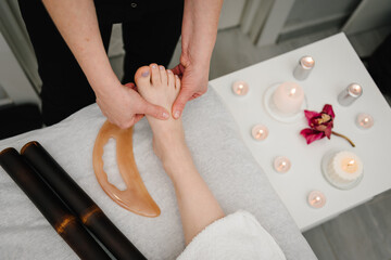 Masseuse massaging leg of client and foot of girl. Manual, aesthetic procedures in spa salon....