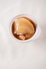hot braised premium shark's fin soup and crab meat scallop in convoy superior stock white bowl on red cloth background chinese seafood banquet halal menu