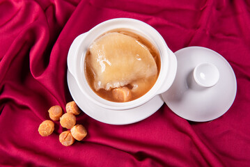 hot braised premium shark's fin soup and crab meat scallop in convoy superior stock white bowl on red cloth background chinese seafood banquet halal menu