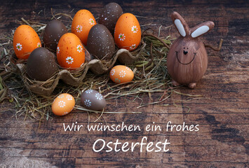 Gru&szlig;karte Frohe Ostern: Braune  und orangefarbene Ostereir mit der Beschriftung Frohe Ostern.