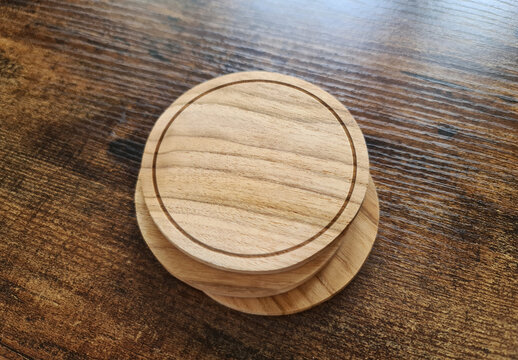 Blank coaster stack mockup with wood texture on wooden surface. Circular drink pad pile template