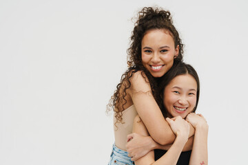 Two cheery girls hugging isolated over white background