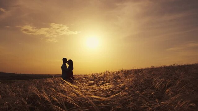 Young beautiful couple hugging while standing on a beautiful field. The concept of relationships with loving partners likes to spend time together.