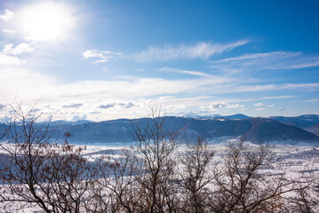 Winter landscape, valley and hills covered with snow on bright sunny day