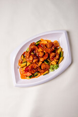 wok fried red sweet and sour spicy sauce with big prawn  and cucumber on wood table chinese banquet seafood halal menu