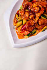 wok fried red sweet and sour spicy sauce with big prawn  and cucumber on wood table chinese banquet seafood halal menu