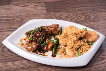 two in one varieties wok fried big prawn with nonya sweet and sour dark sauce and cereal butter prawn with curry leaf on wood table chinese halal banquet seafood menu