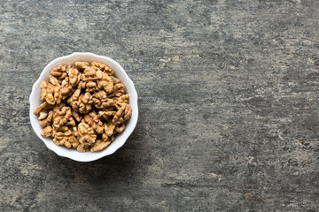 Fresh healthy walnuts in bowl on colored table background. Top view Healthy eating bertholletia concept. Super foods
