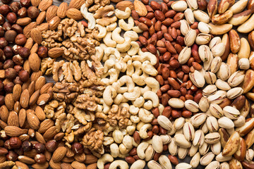 different nuts background. Close up, top view, flat lay. Walnut, pistachios, almonds, hazelnuts and cashews