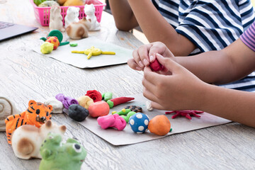 Obraz na płótnie Canvas Different shapes and colors of plasticine of the LD children are molded and placed on a table in front of them to train, to concentrate and to increase their brain skills, soft and selective focus.