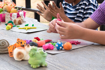 Obraz na płótnie Canvas Different shapes and colors of plasticine of the LD children are molded and placed on a table in front of them to train, to concentrate and to increase their brain skills, soft and selective focus.