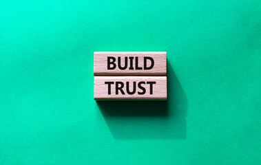 Build trust symbol. Wooden blocks with words Build trust. Beautiful green background. Business and Build trust concept. Copy space.