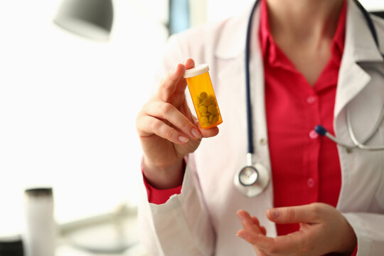 Closeup of doctor holding container of medical pills