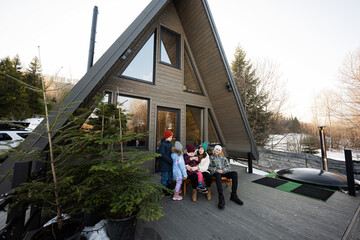 Mother with four children sit on terrace off grid tiny house in the mountains.