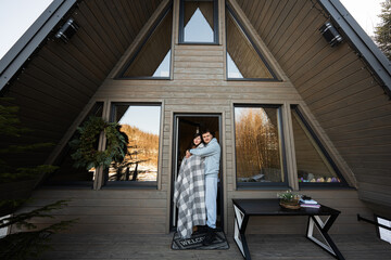 Couple in love on terrace off grid tiny house in the mountains.