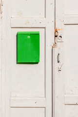 Green box on a brown wooden old door. Nastalgia.