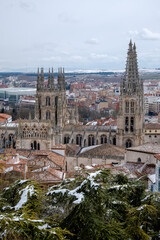Paisaje de la Catedral de Burgos vista desde el mirador del castillo de la ciudad con todas las casa rodeándola bajo un cielo nublado.