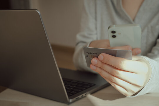 Woman hands holding plastic credit card and using laptop. Online shopping or payment concept. Toned picture. High quality photo. 