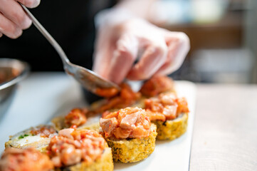 professional chef's hands making sushi roll in a restaurant kitchen