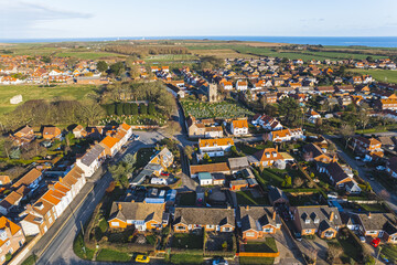 scenic drone shot of small orange houses and fields near to the ocean, Flamborough, United Kingdom. High quality photo