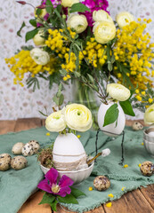 Obraz na płótnie Canvas Tischdekoration im Frühling mit frischen Blumen und Muffins, Blumenstrauß und Gepäck auf einem Tisch