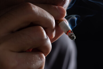 Smoking cigarette in the hand of young man close up
