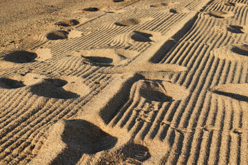 Beach sand background, marks and footprints.