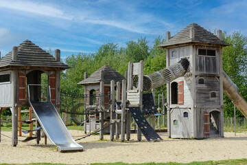 Children's eco playground in Europe. Several wooden houses for children on the ecological playground on the summer day