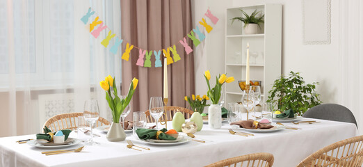 Festive Easter table setting with yellow tulips indoors, banner design