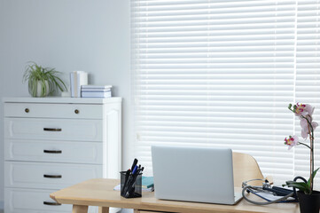 Modern clinic interior with wooden furniture and laptop