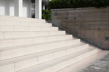 Fototapeta na wymiar Outdoor beige stairs with ramp and metal railings