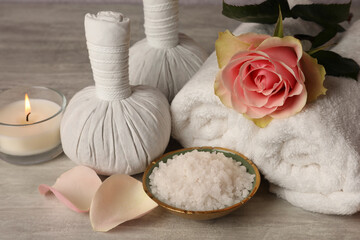 Composition with spa products, rose and candle on grey wooden table, closeup