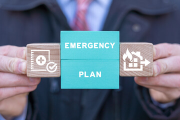 Man holding colorful blocks with icons and inscription: EMERGENCY PLAN. Concept of Emergency...