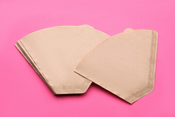 Paper coffee filters on pink background, above view