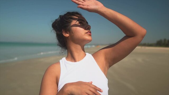 beautiful girl hiding her face and eyes from the sun while looking into the sky
