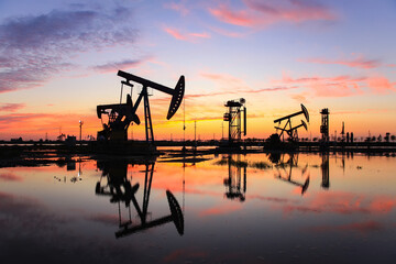 in the evening, oil pumps are running, The oil pump and the beautiful sunset reflected in the...
