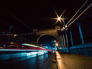 bridge at night with vehicles light trails