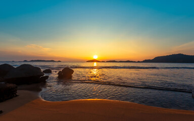 Beach and rocks in seaside. Beautiful dramatic ocean sunset