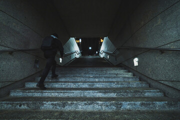man on stairs of underground tunnel